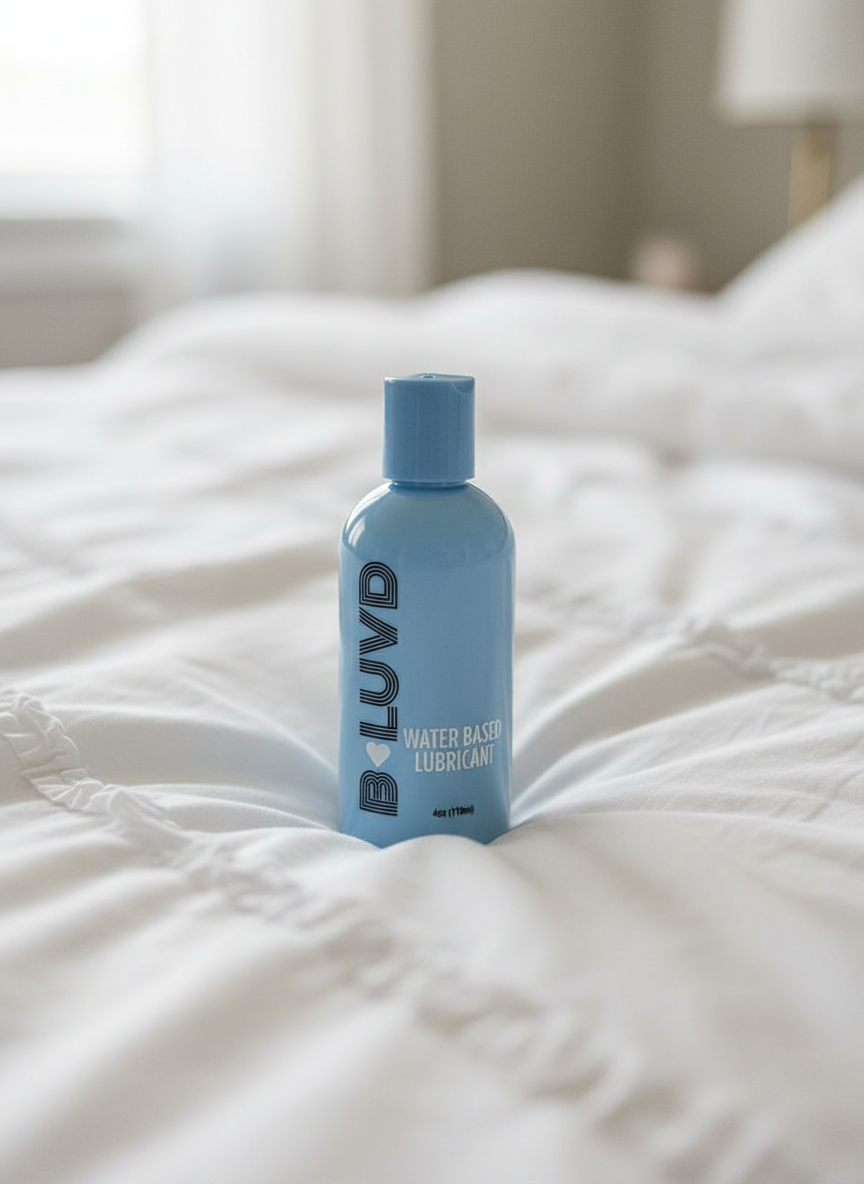 B-Luvd Water Based Lubricant blue bottle on a bed 