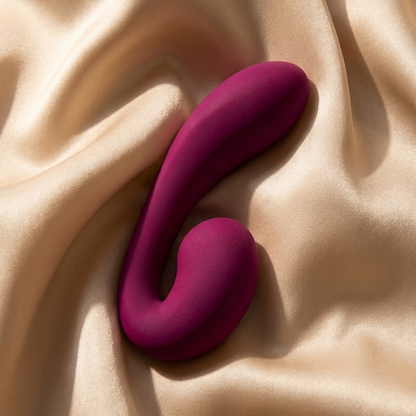 A purple Zya Vibrator laying on a sheet.