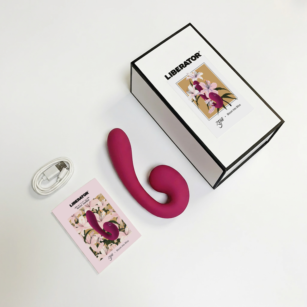 A the contents for a purple Zya Vibrator including the pamphlet, charging cable and box.