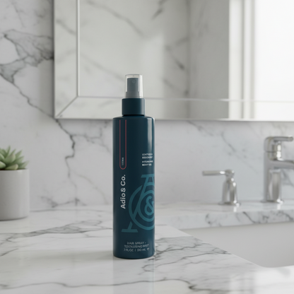 Dark blue bottle of hydrating body oil titan on a bathroom counter
