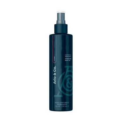 A bottle of Lustra Hydrating Body Oil with a colorful design featuring various abstract shapes and a spray nozzle.