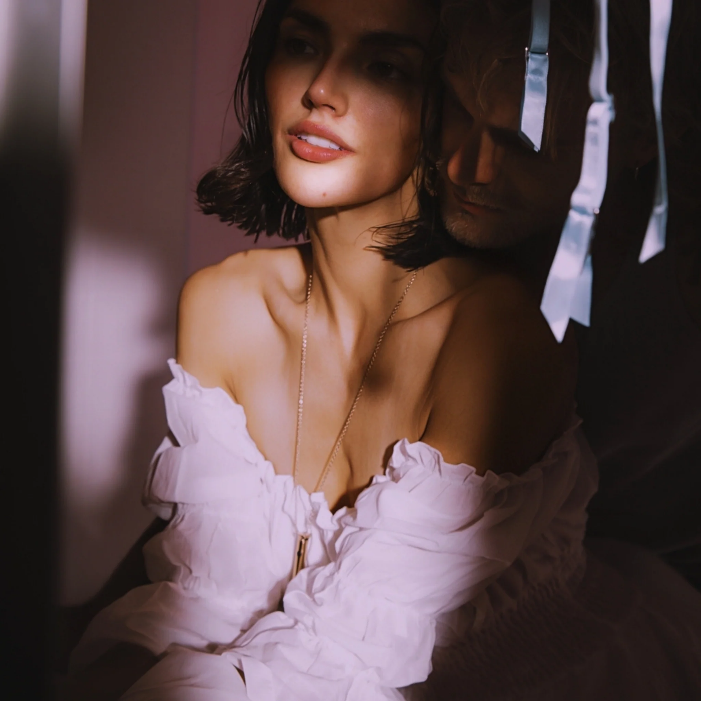 Woman wearing a white off-shoulder top with vesper 2 necklace on